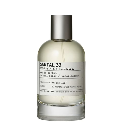 Chic bottle of perfume, vanilla scented tobacco on light background with sticks and vanilla flowers, dry tobacco leaf